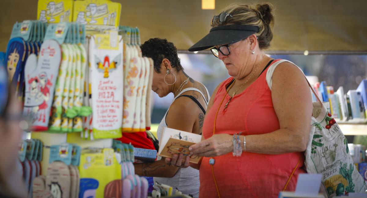 Diana Drummey of La Mesa browses one of the books for sale during the San Diego Union-Tribune Festival of Books.