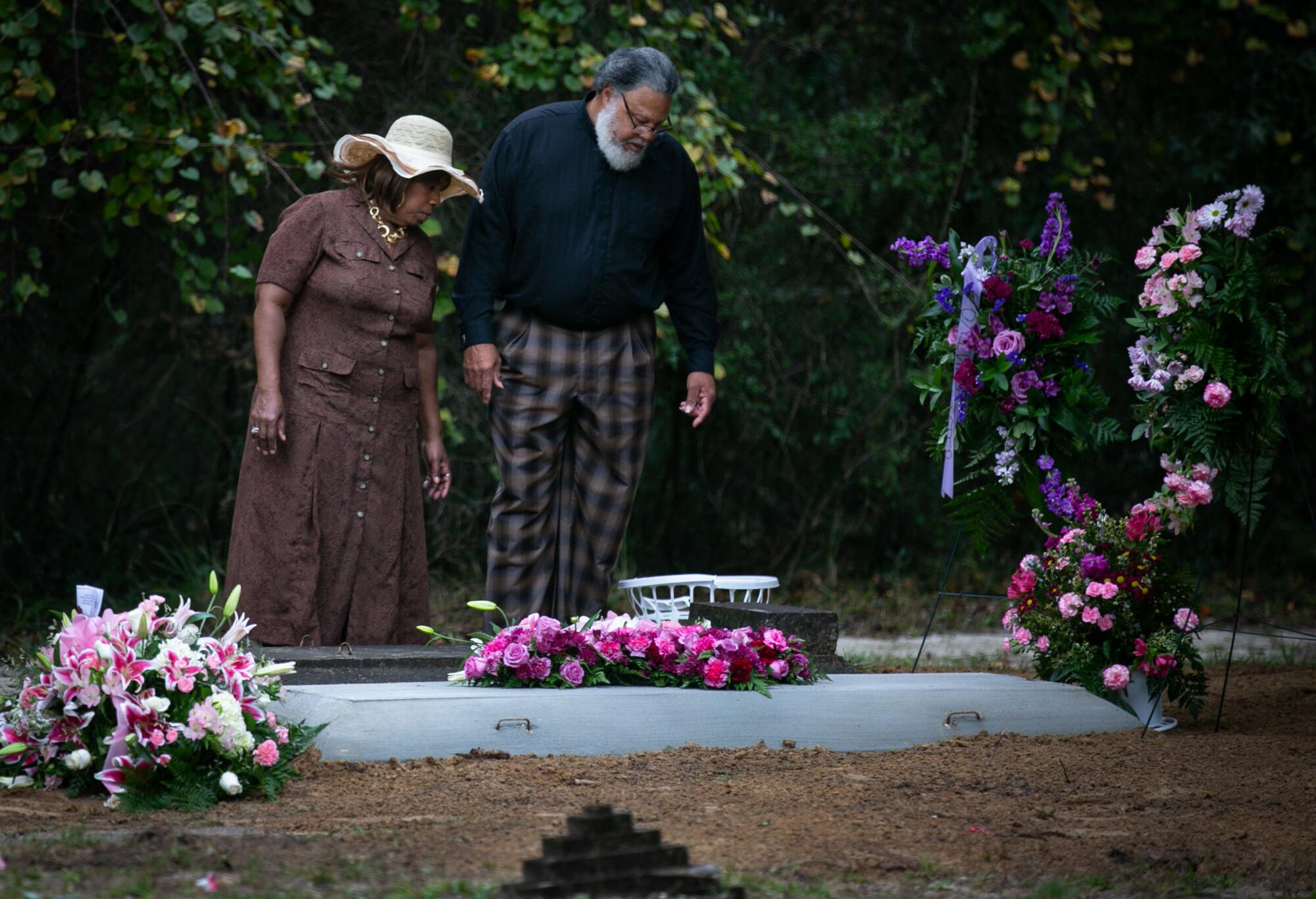 El pastor Albert Mann y su esposa, Valencia Jenkins-Mann, visitan la tumba de su madre, Ella Cuthbert.