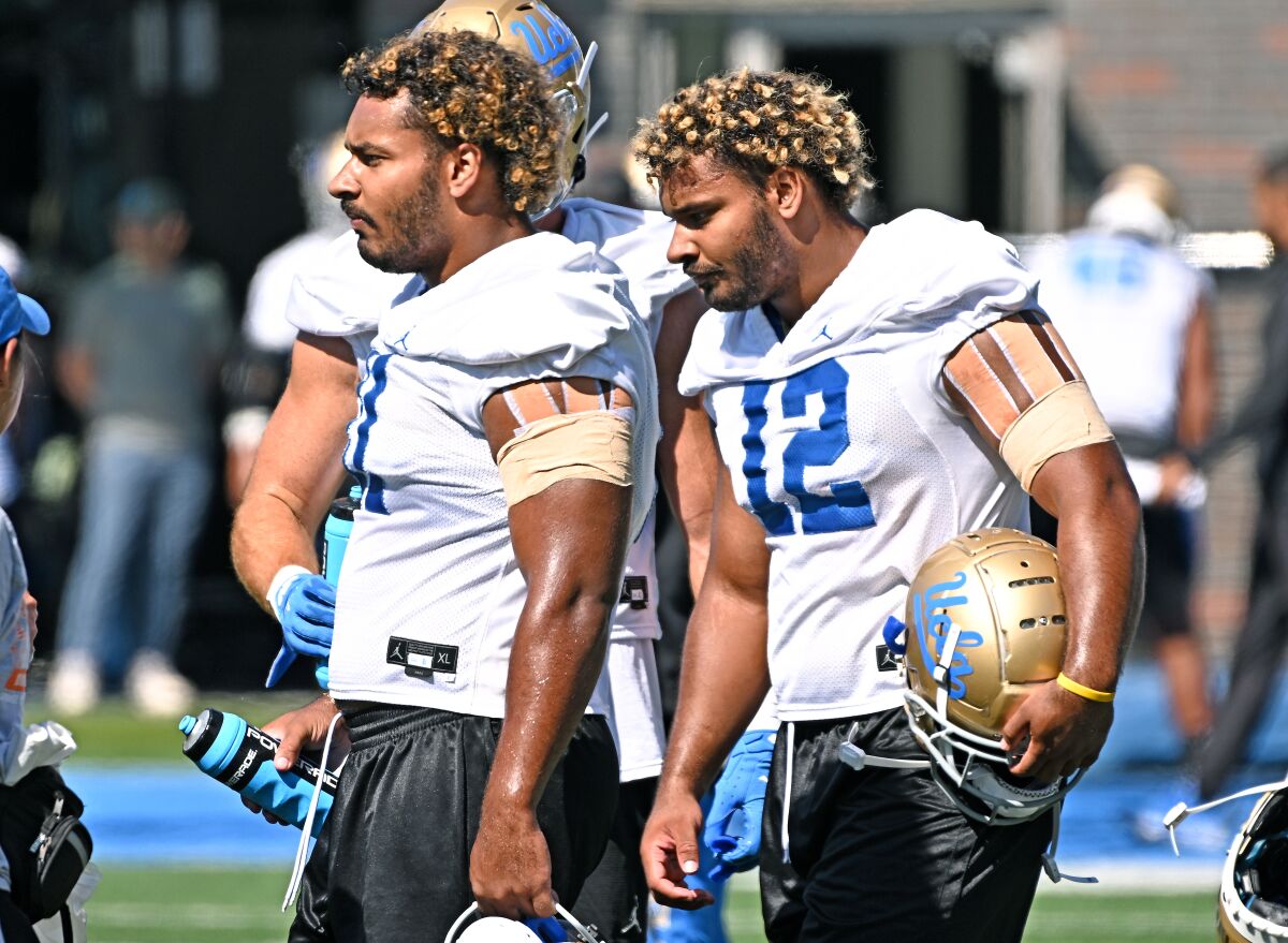 UCLA's Gabriel (left) and Grayson Murphy take a break during practice August 18.