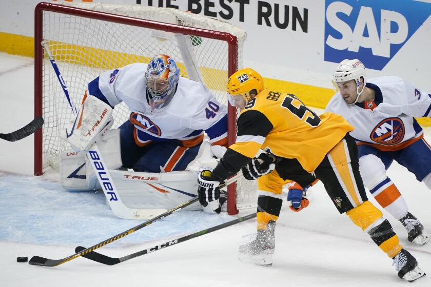 Pittsburgh Penguins' Jake Guentzel (59) can't get a wrap-around shot past New York Islanders goaltender Semyon Varlamov (40) with Adam Pelech (3) defending during the third period in Game 2 of an NHL hockey Stanley Cup first-round playoff series in Pittsburgh, Tuesday, May 18, 2021. The Penguins won 2-1. (AP Photo/Gene J. Puskar)