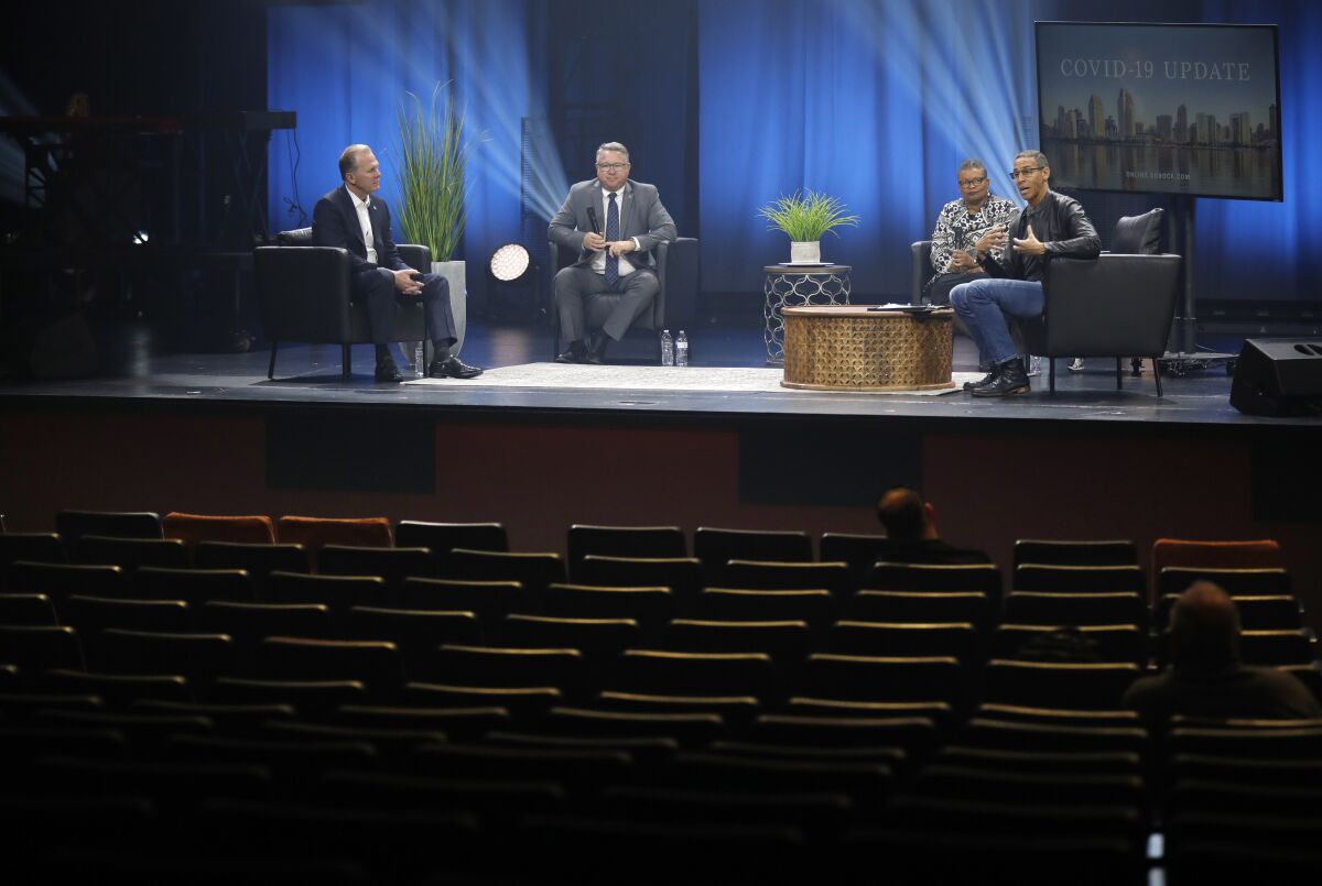 Pastor Miles McPherson, right, interviewed San Diego Mayor Kevin Faulconer, left, El Cajon Mayor Bill Wells and Dr. Wilma Wooten from San Diego County Health and Human Services during a live streamed service at the Rock Church on Sunday. The Rock Church is holding online services due to the coronavirus. A few essential staff sat in the seats.