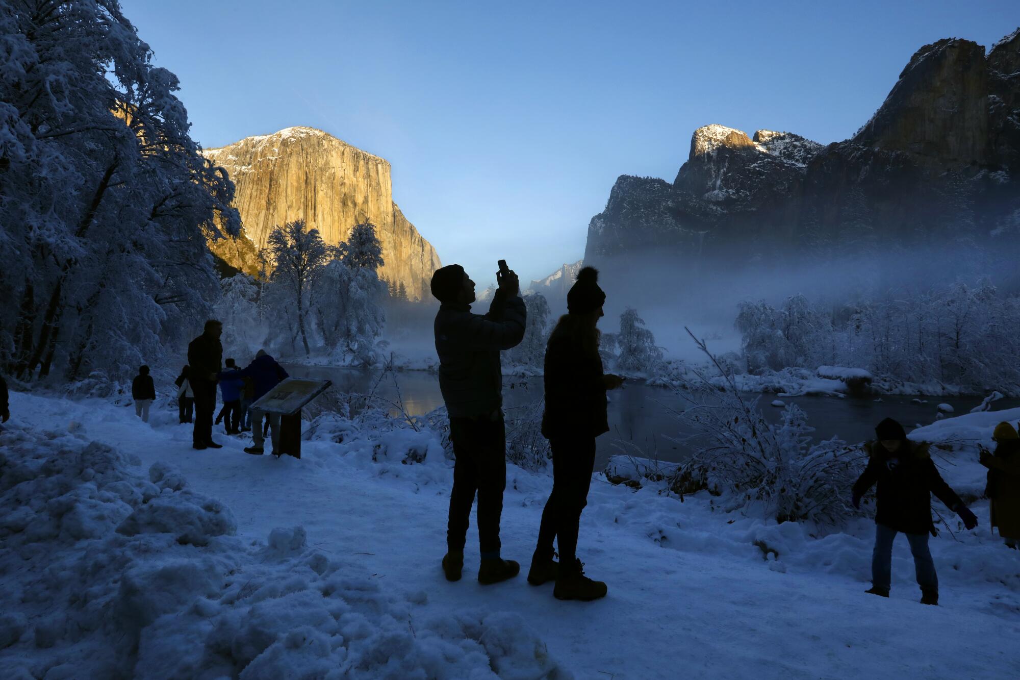 People take pictures of snow in Yosemite National Park.