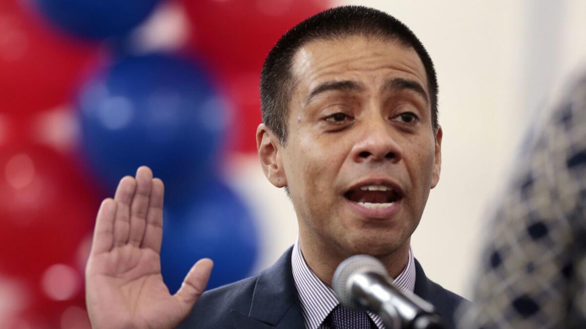 L.A. school board member Ref Rodriguez, shown taking the oath of office in 2015, has raised complex questions by resisting calls to step aside since being charged with political money laundering.