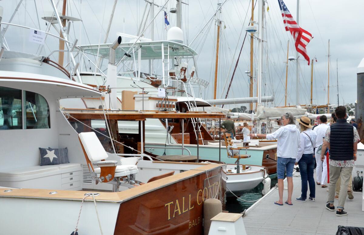 Boat aficionados stroll the docks during the 2023 Newport Beach Wooden Boat Festival.