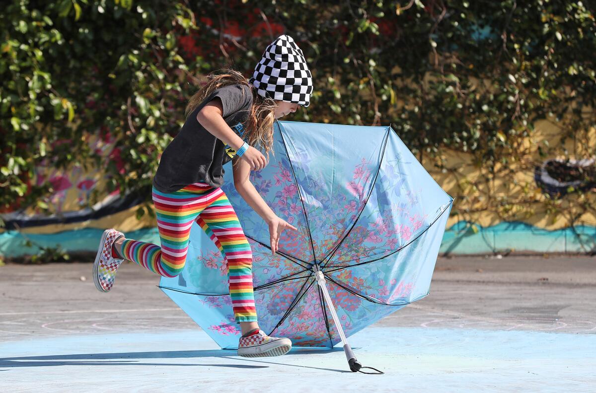 A youngster scoops up an umbrella during the "Look Up" flash art experience at the Boys & Girls Club of Laguna Beach.