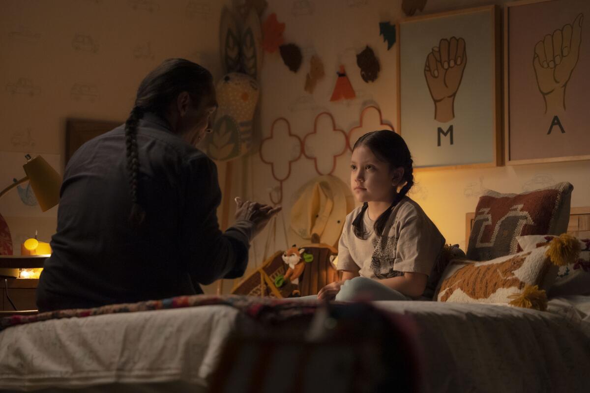 A father talking to his child on her bed