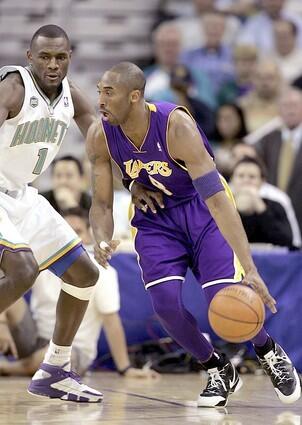Kobe Bryant of the Los Angeles Lakers drives around Kirk Snyder of the New Orleans/Oklahoma City Hornets.
