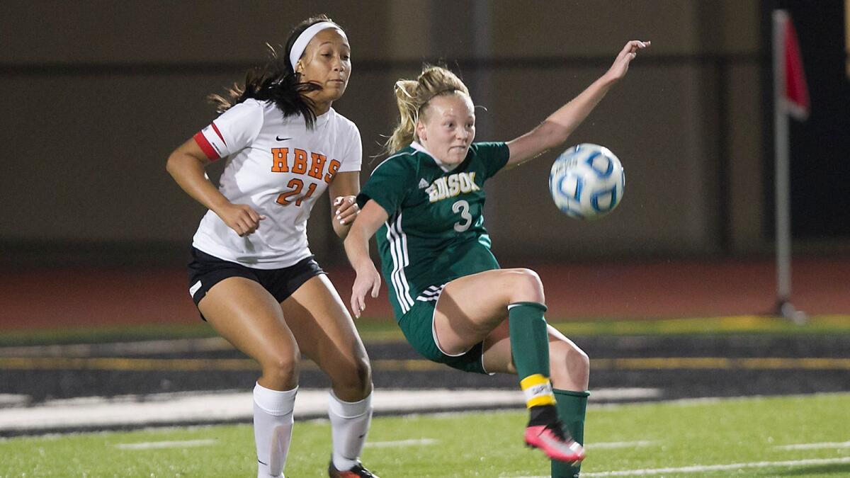 Edison's Michael Guptill, 3, attempts a bicycle kick shot to the goal as Huntington's Brianna Barnes defends during a game on Jan. 18. The Sunset League rivals played to a 1-1 draw and did not go to overtime, per a new league rule.