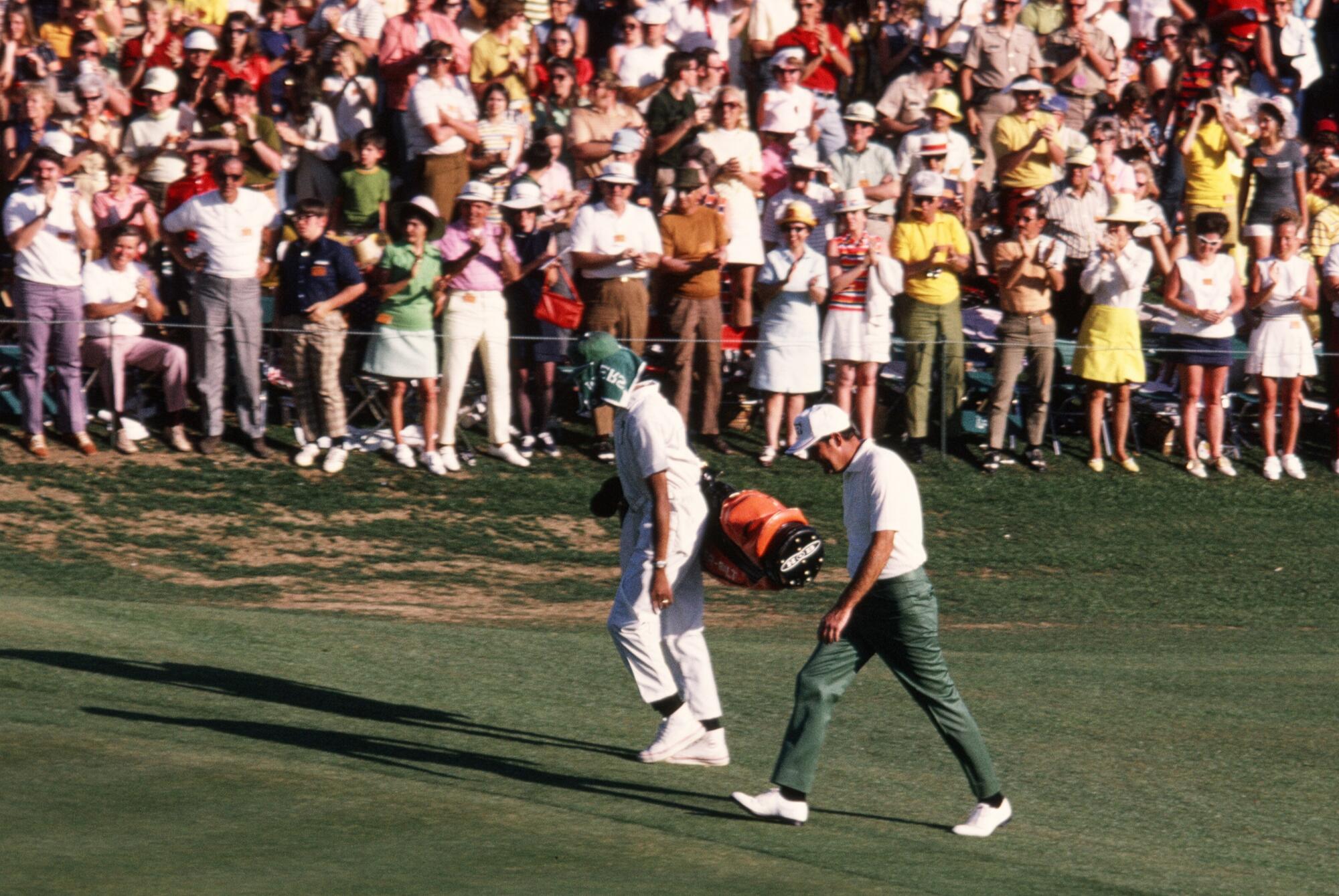  Masters Champion Charles Coody walks to the 18th green with his caddie, Walter Prichett,  in the 1971 Masters Tournament