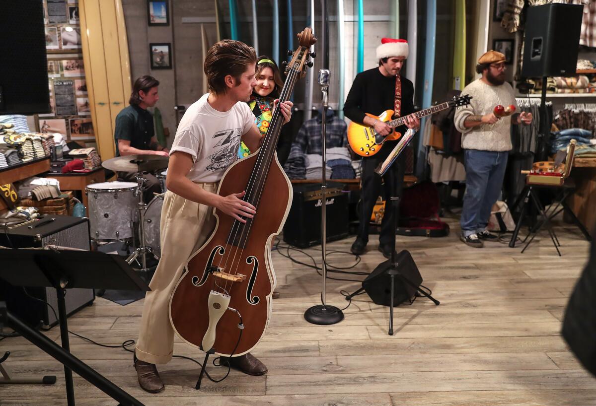 Members of the band Moonshine entertain guests at Hobie Surf Shop during Hospitality Night in Laguna Beach on Friday.