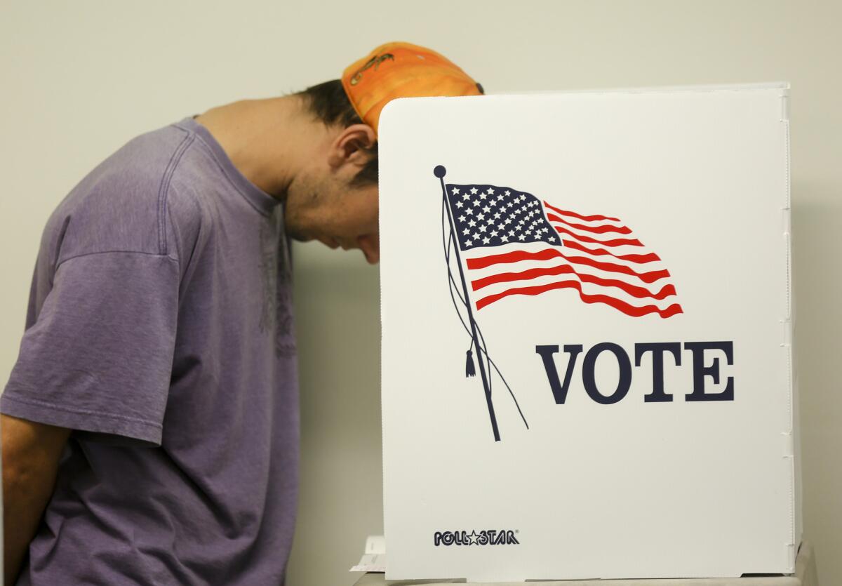 A voter studies his ballot Monday while at the Los Angeles County Registrar-Recorder office in Norwalk.