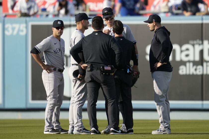New York Yankees right fielder Aaron Judge, center right, is checked out after catching a fly ball hit by Los Angeles Dodgers' J.D. Martinez during the eighth inning of a baseball game in Los Angeles, Saturday, June 3, 2023. (AP Photo/Ashley Landis)