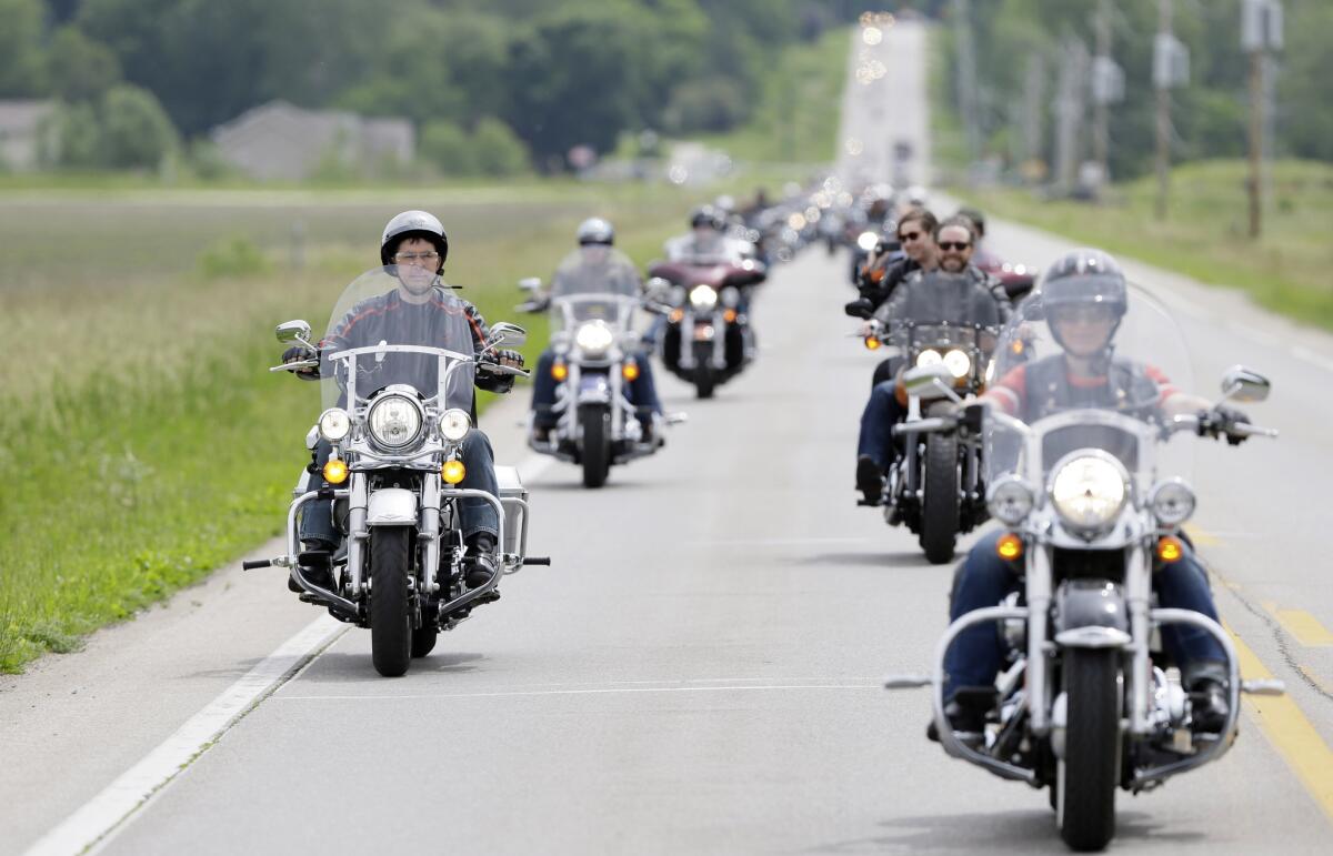 Wisconsin Gov. Scott Walker, left, rides in a motorcycle convoy with freshman Iowa Sen. Joni Ernst, right, the host of "Joni's 1st Annual Roast and Ride," in Boone, Iowa, on Saturday.