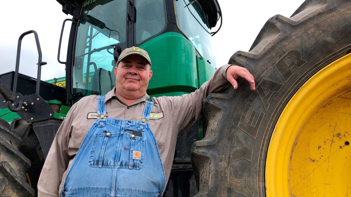 Bernard Peterson leans on a tractor at his farm in Loretto, Ky. At Peterson's farm, eight members of the family partnership collected a total of $863,560 in aid for crops they grow in seven counties.