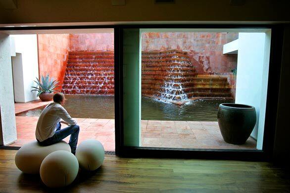 When Tim Campbell was hired to redesign a Los Angeles property with a fountain credited to Mexican master architect Luis Barragán, he faced not only the pressure of building next to a potential piece of architectural history, but also the task of sorting out the jumbled house around it. Here, Campbell sits in an expansive entertaining area with sliding glass doors open to the pool and fountain.