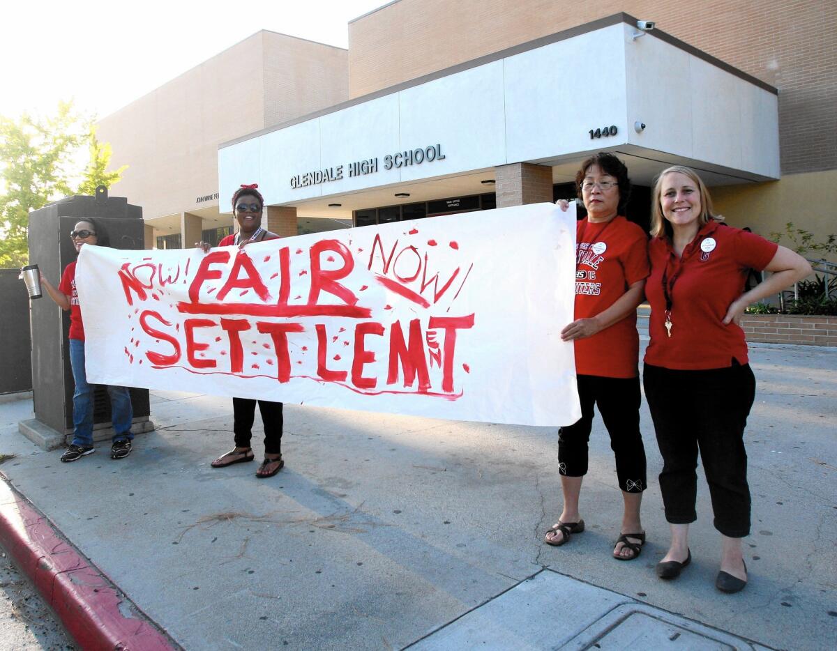 Glendale High School personnel hold signs up asking for a wage increase on Sept. 25. Pay raises were approved by the school board on Tuesday for more than 1,000 GUSD teachers.