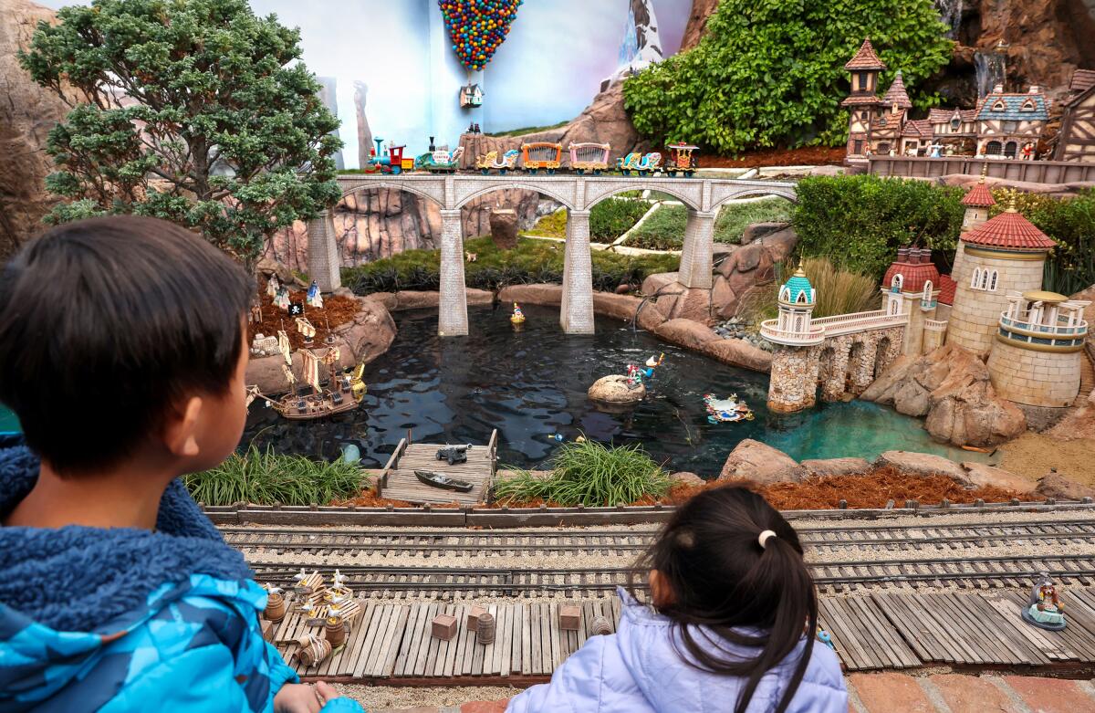 Young visitors look out onto a portion of a railroad and lagoon-like setting within the Sheegogs’ massive attraction.