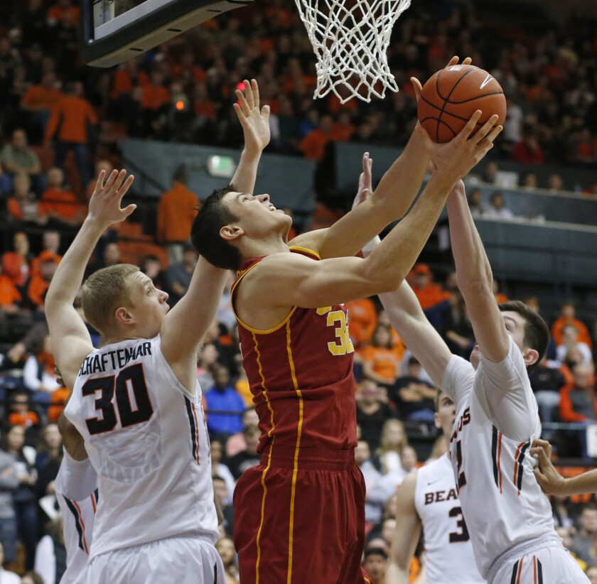 USCs Nikola Jovanovic, center, goes to the basket while being guarded by Oregon State's Olaf Schaftenaar, left, and Drew Eubanks in the second half of a game on Jan. 24.