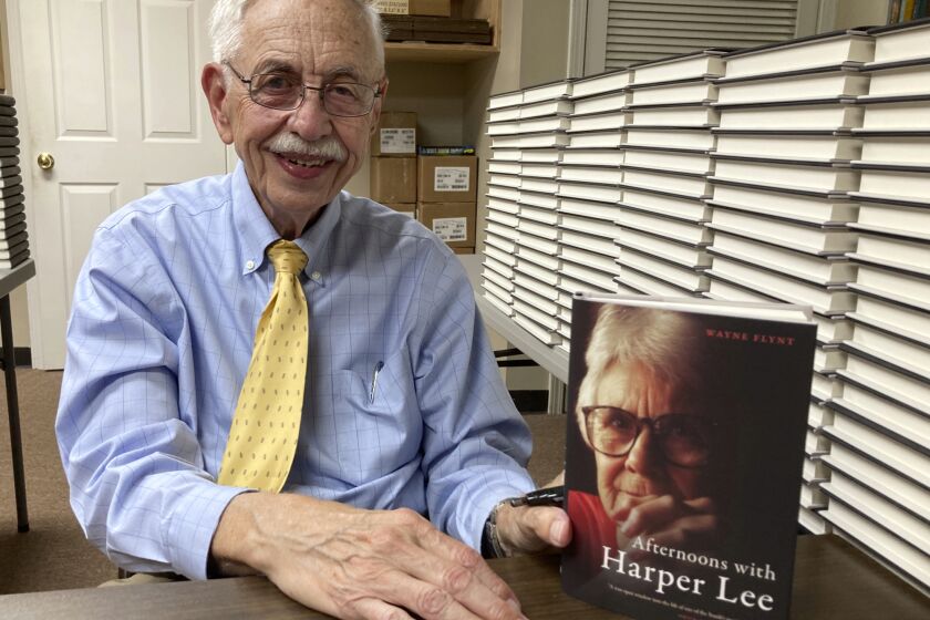 Alabama historian Wayne Flynt holds a copy of his new book, "Afternoons with Harper Lee," about the late author of "To Kill a Mockingbird," at a book-signing in Homewood, Ala., on Thursday, Sept. 22, 2022. Flynt and his late wife were friends with Lee, who died in 2016. (AP Photo/Jay Reeves)