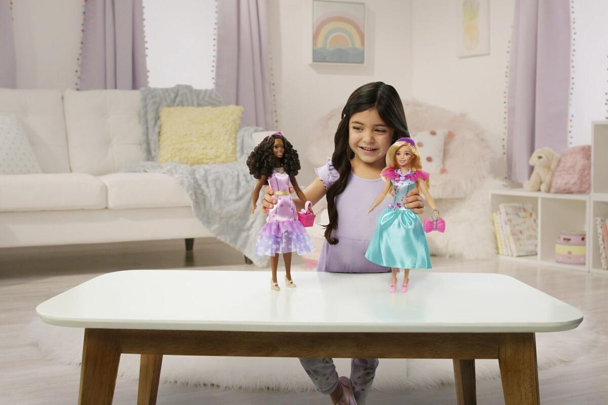 En esta imagen proporcionada por Mattel, una niña juega con muñecas My First Barbie hechas para niños