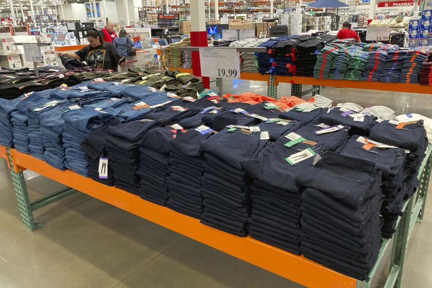 Shoppers peruse jeans on display in a Costco warehouse Monday, Aug. 15, 2022, in Sheridan, Colo. (AP Photo/David Zalubowski)