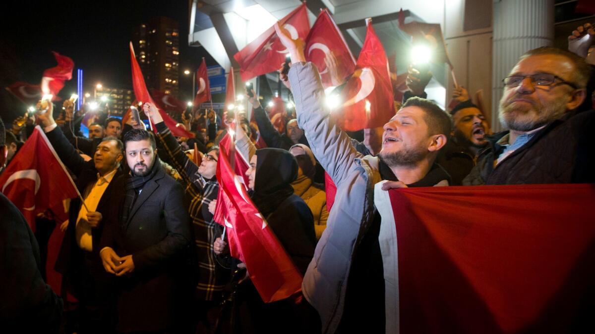 Demonstrators wave Turkish flags outside the Turkish consulate in Rotterdam, Netherlands, Saturday, March 11, 2017.