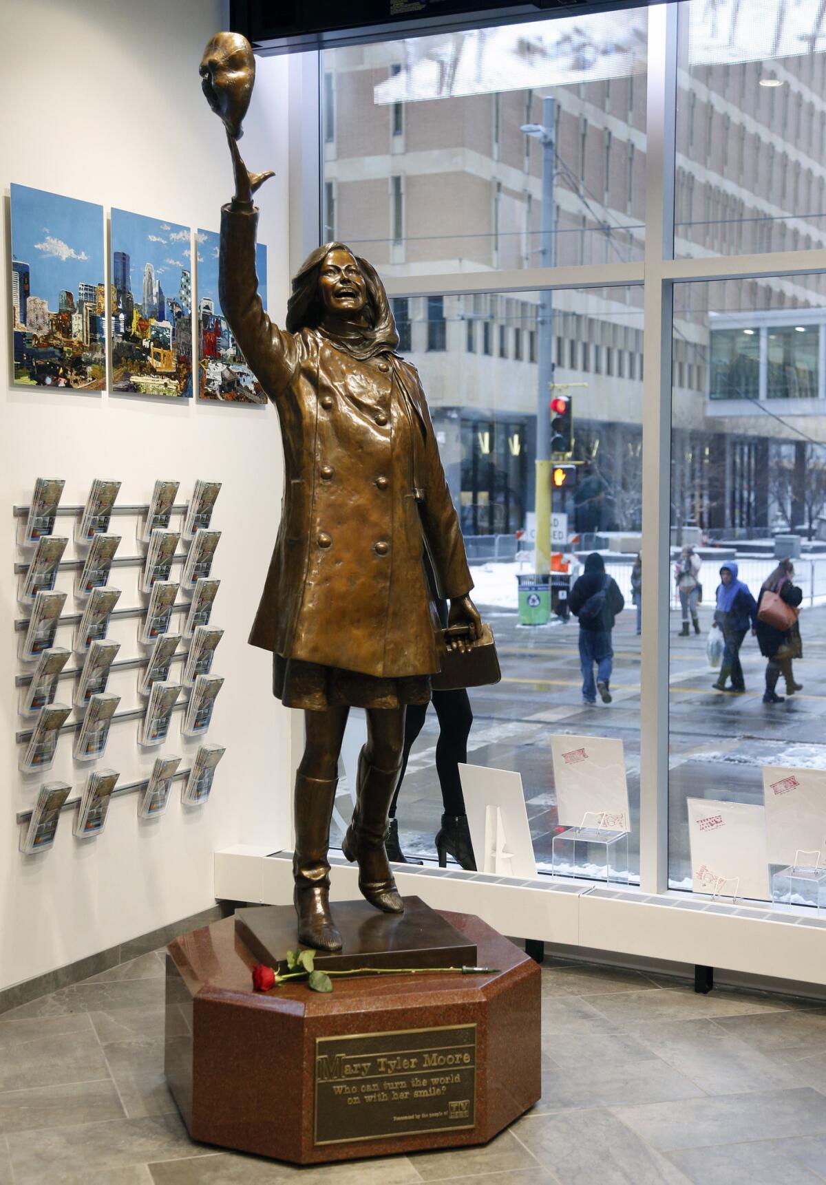 A single rose sits by the life-size bronze statue of Mary Tyler Moore at the Minneapolis Visitor Center, on Wednesday.