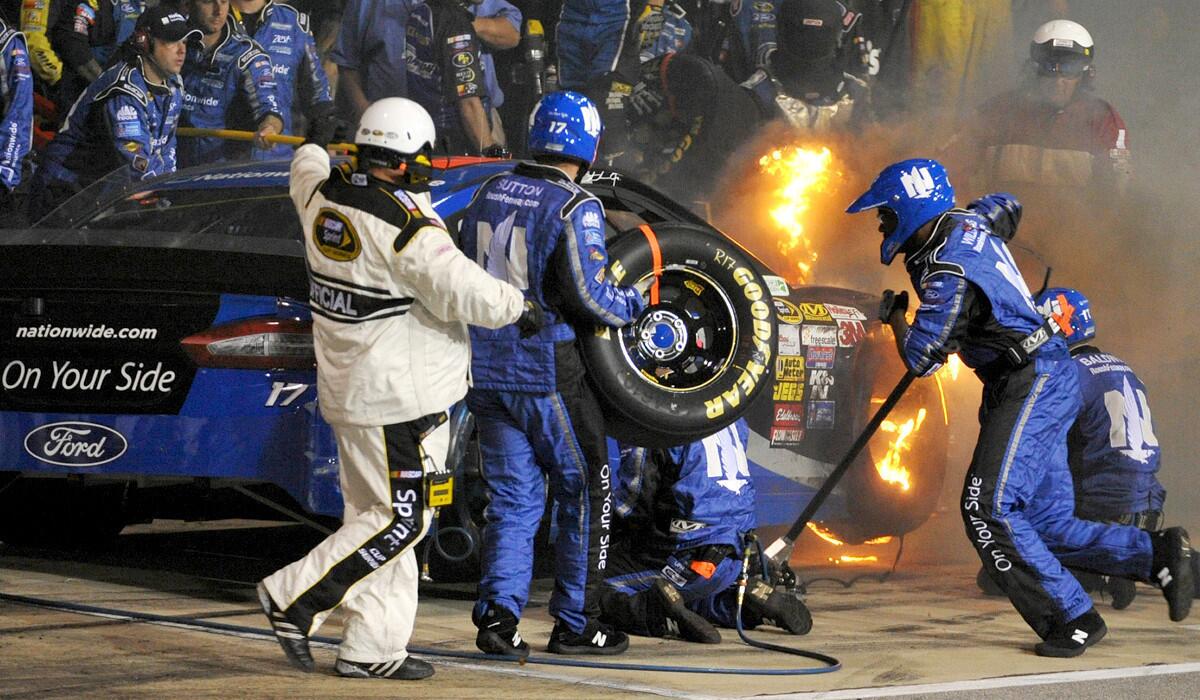 The car of NASCAR driver Ricky Stenhouse Jr. pits while on fire during the Sprint Cup Series Toyota Owners 400 at Richmond International Raceway on Saturday night.