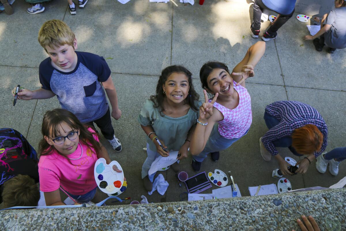 Alumnos posan para una foto mientras pintan un mural en la escuela Spokane Community College 