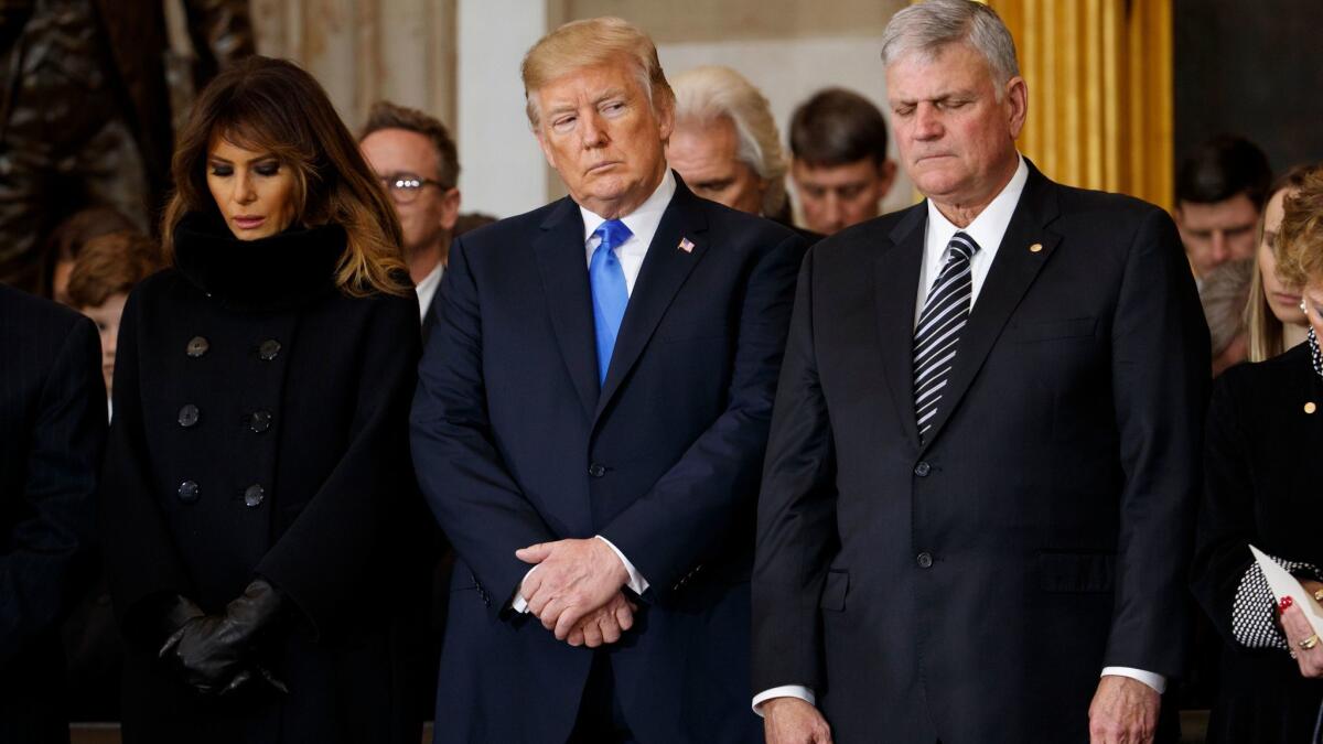 President Trump, with First Lady Melania Trump and Franklin Graham, bows his head in prayer during a ceremony honoring the late Rev. Billy Graham at the U.S. Capitol building on Feb. 28.