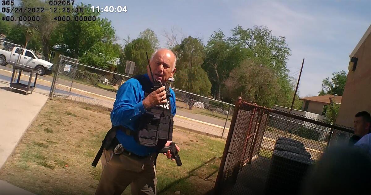 Uvalde, Texas, police Lt. Mariano Pargas holds a walkie talkie and a gun