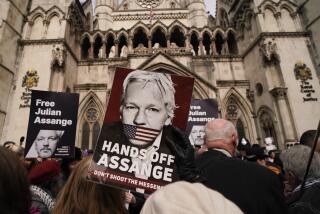 A demonstrator holds a placard, after Stella Assange, wife of Wikileaks founder Julian Assange, released a statement outside the Royal Courts of Justice, in London, Tuesday, March 26, 2024. Two High Court judges said they would grant Assange a new appeal unless U.S. authorities give further assurances about what will happen to him. The case has been adjourned until May 20. (AP Photo/Alberto Pezzali)