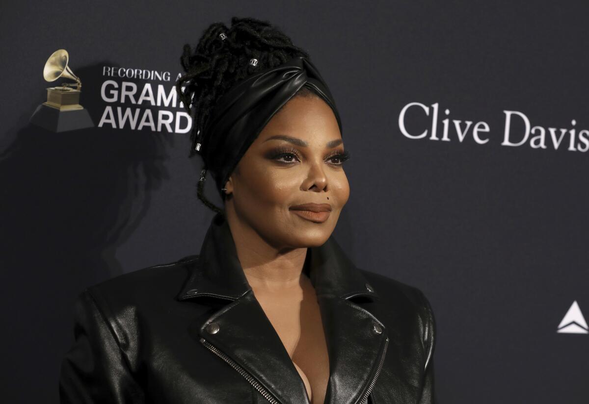 Janet Jackson posing in a black leather jacket