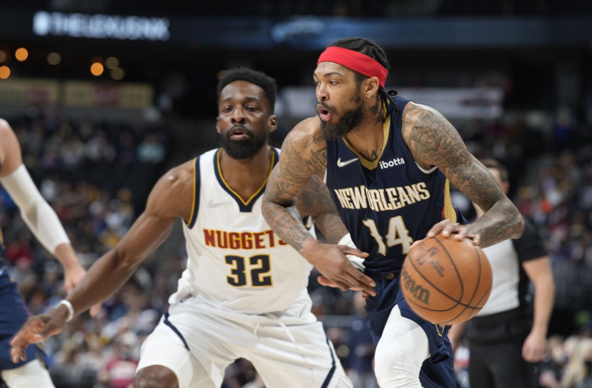 New Orleans Pelicans forward Brandon Ingram, right, drives past Denver Nuggets forward Jeff Green in the second half of an NBA basketball game Sunday, March 6, 2022, in Denver. (AP Photo/David Zalubowski)