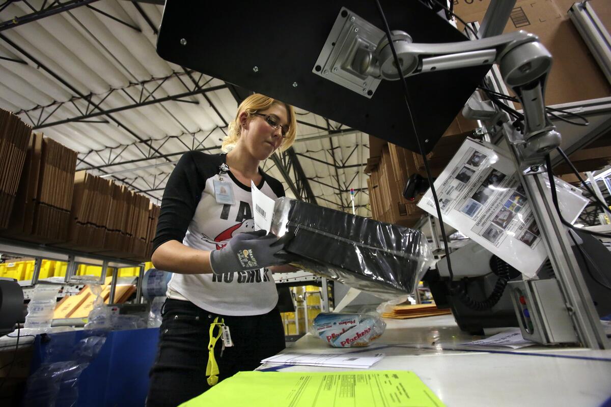 A worker fills an order at an Amazon Fulfillment Center in San Bernardino.