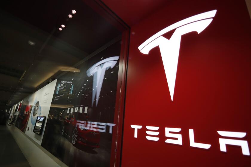 FILE- In this Feb. 9, 2019 file photo, a sign bearing the company logo is displayed outside a Tesla store in Cherry Creek Mall in Denver. A new automatic lane-change feature of Teslas Autopilot system doesnt work well and could be a safety risk to drivers, according to tests performed by Consumer Reports. Senior Director of Auto Testing Jake Fisher said in a statement Wednesday, May 22, that the system doesnt appear to react to brake lights or turn signals, and it cant anticipate what other drivers will do. (AP Photo/David Zalubowski, File)
