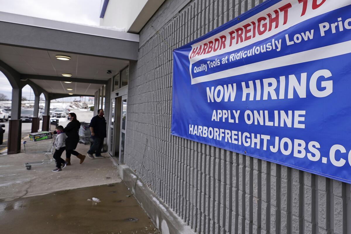 A sign outside Harbor Freight Tools says "Now Hiring"