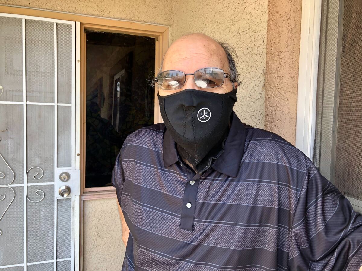 Michael Martinez, 69, poses with a mask on in front of a home in Las Vegas.