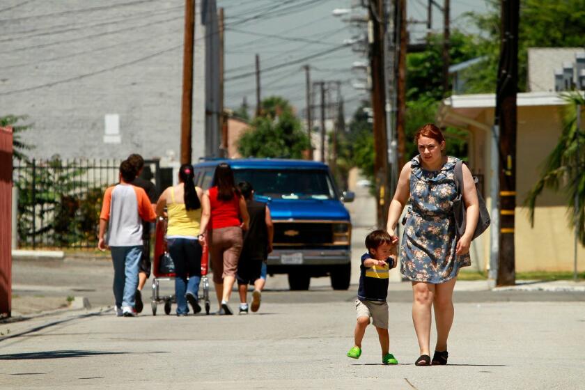 Baylen, Liz  B58574209Z.1 BELL, CA  JULY 14, 2010 (Right) Angie Rivera, 17, walks with her nephew Nikolia De Anda, 1, down an alley off Gage Ave near Bell City Hall on July 17. ( Liz O. Baylen / Los Angeles Times )