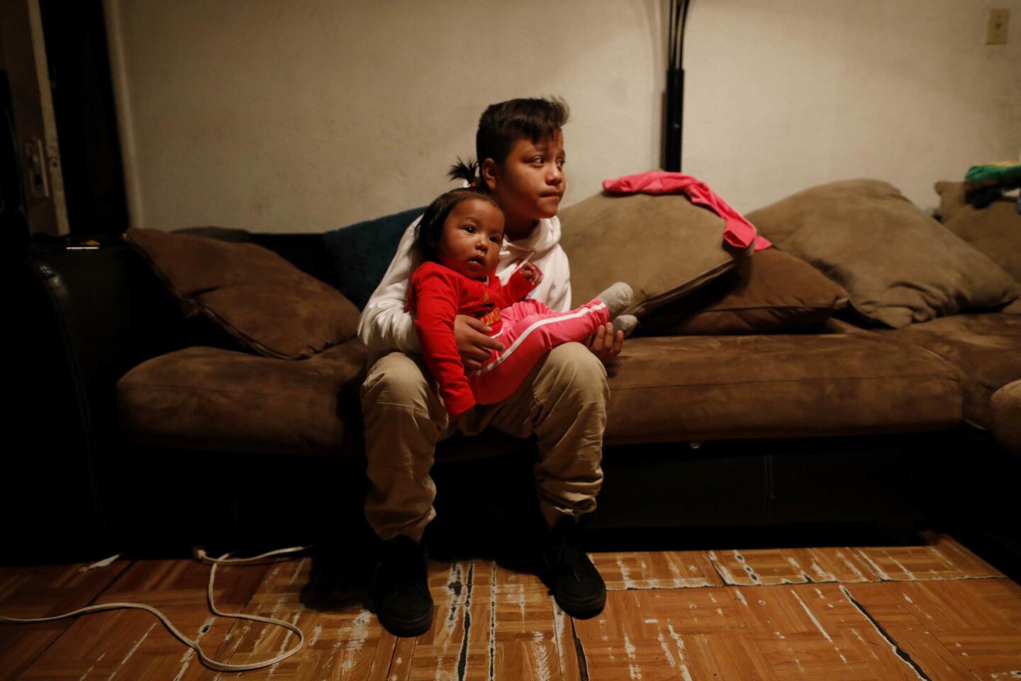 Angel Flores, 11, a fifth-grader at Trinity Elementary School, watches sister Kendy, 12 months, before heading to the picket line at his school. His mother, Kimberly Martinez, decided to keep her children out of school to support the strike.