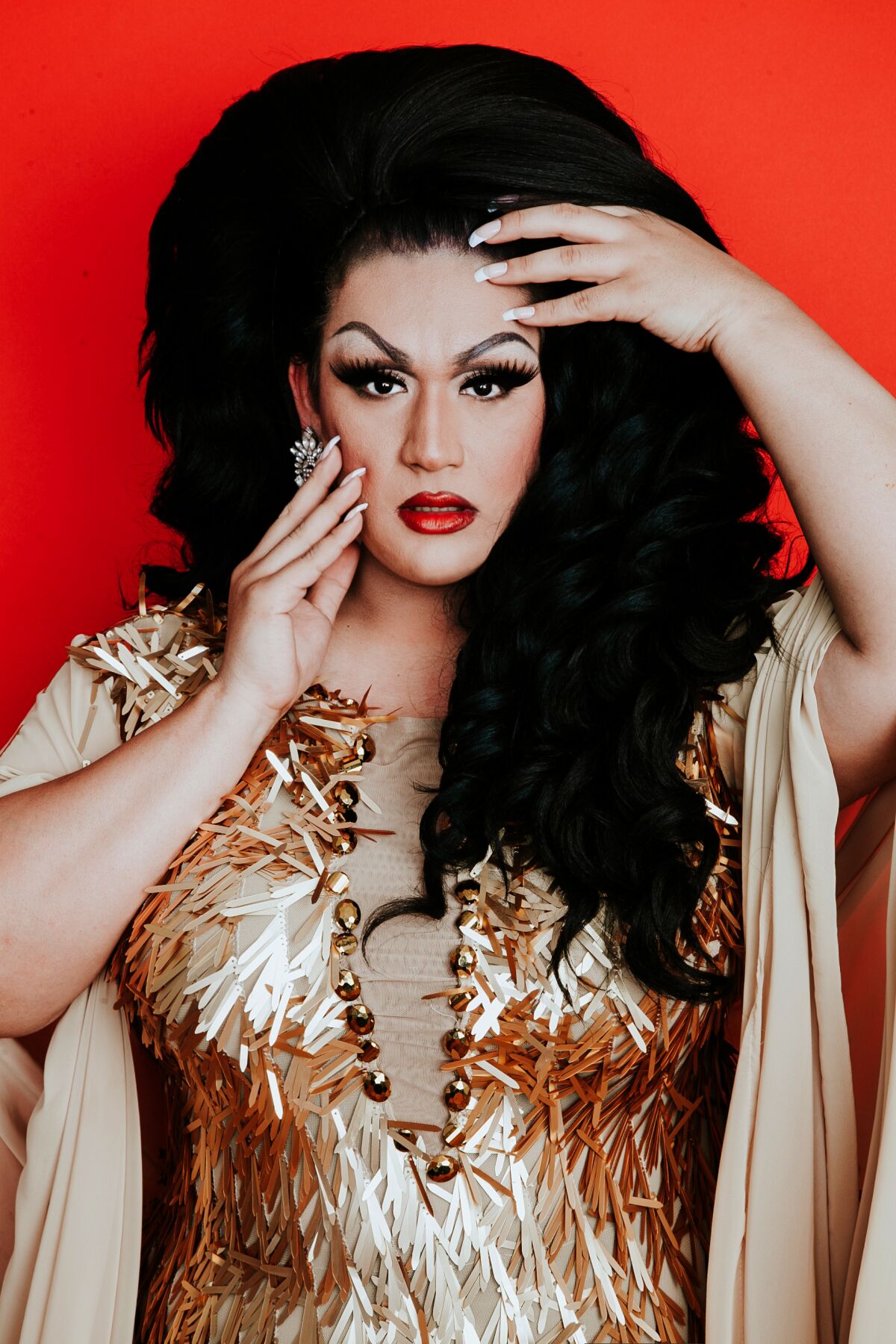 A person in a high wig strikes a dramatic pose.