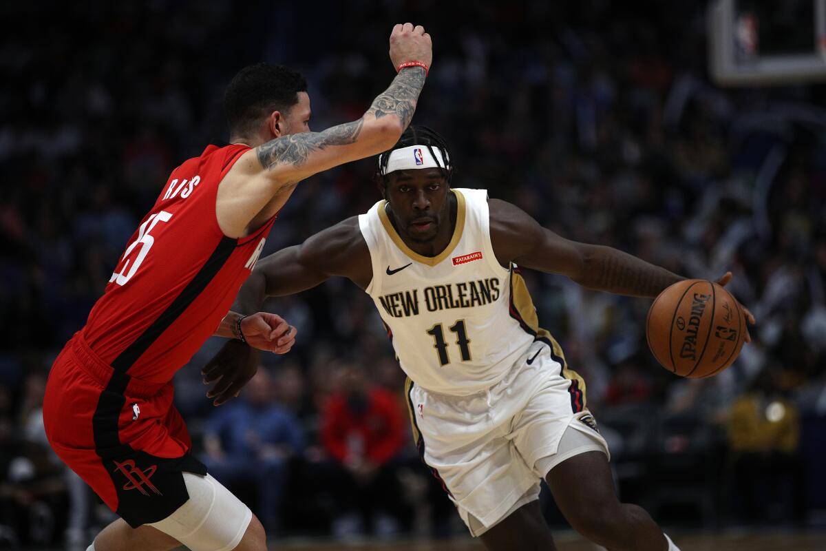 Pelicans guard Jrue Holiday drives against Rockets guard Austin Rivers on Dec. 29 in New Orleans.