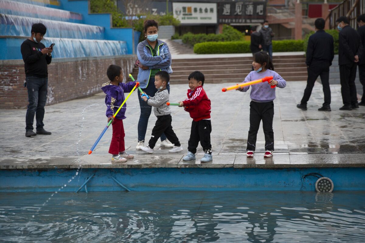 Children play with water toys at a public square in Aksu in western China's Xinjiang Uyghur Autonomous Region, Tuesday, April 20, 2021. Xinjiang in far western China had the sharpest known decline in birthrates between 2017 and 2019 of any territory in recent history, according to a new analysis by an Australian think tank. (AP Photo/Mark Schiefelbein)