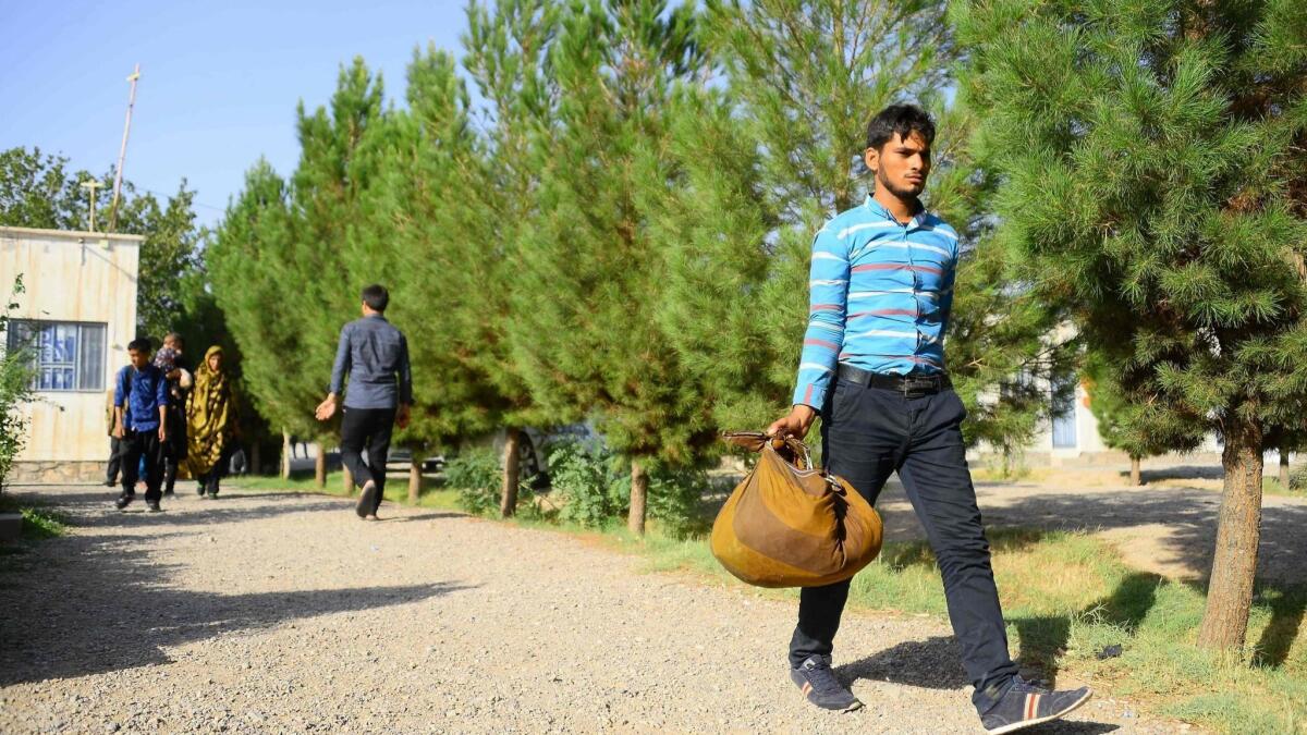 An Afghan man returns to the Afghan province of Herat from Iran, part of an exodus of migrant workers fleeing Iran's economic turmoil.