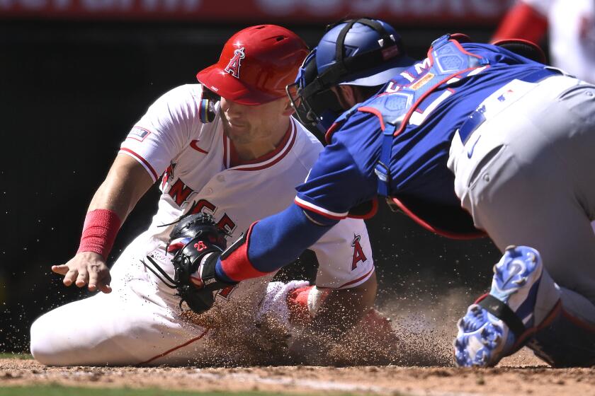 Los Angeles Angels' Matt Thaiss, left, is tagged out by Texas Rangers' Jonah Heim, right, during the seventh inning of a baseball game Sunday, Sept. 29, 2024, in Anaheim, Calif. (AP Photo/John McCoy)