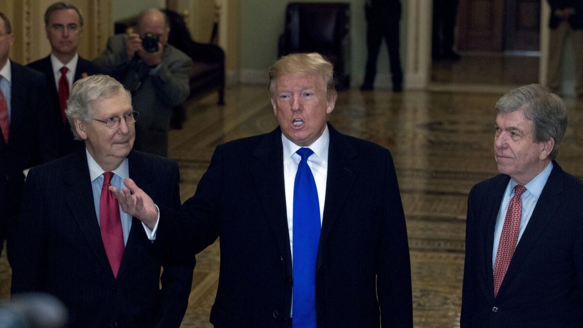 President Trump, accompanied by Senate Majority Leader Mitch McConnell (R-Ky.), left, and Sen. Roy Blunt (R-Mo.), talks to reporters as he arrives for a Senate Republican policy lunch on Capitol Hill in Washington on Tuesday.