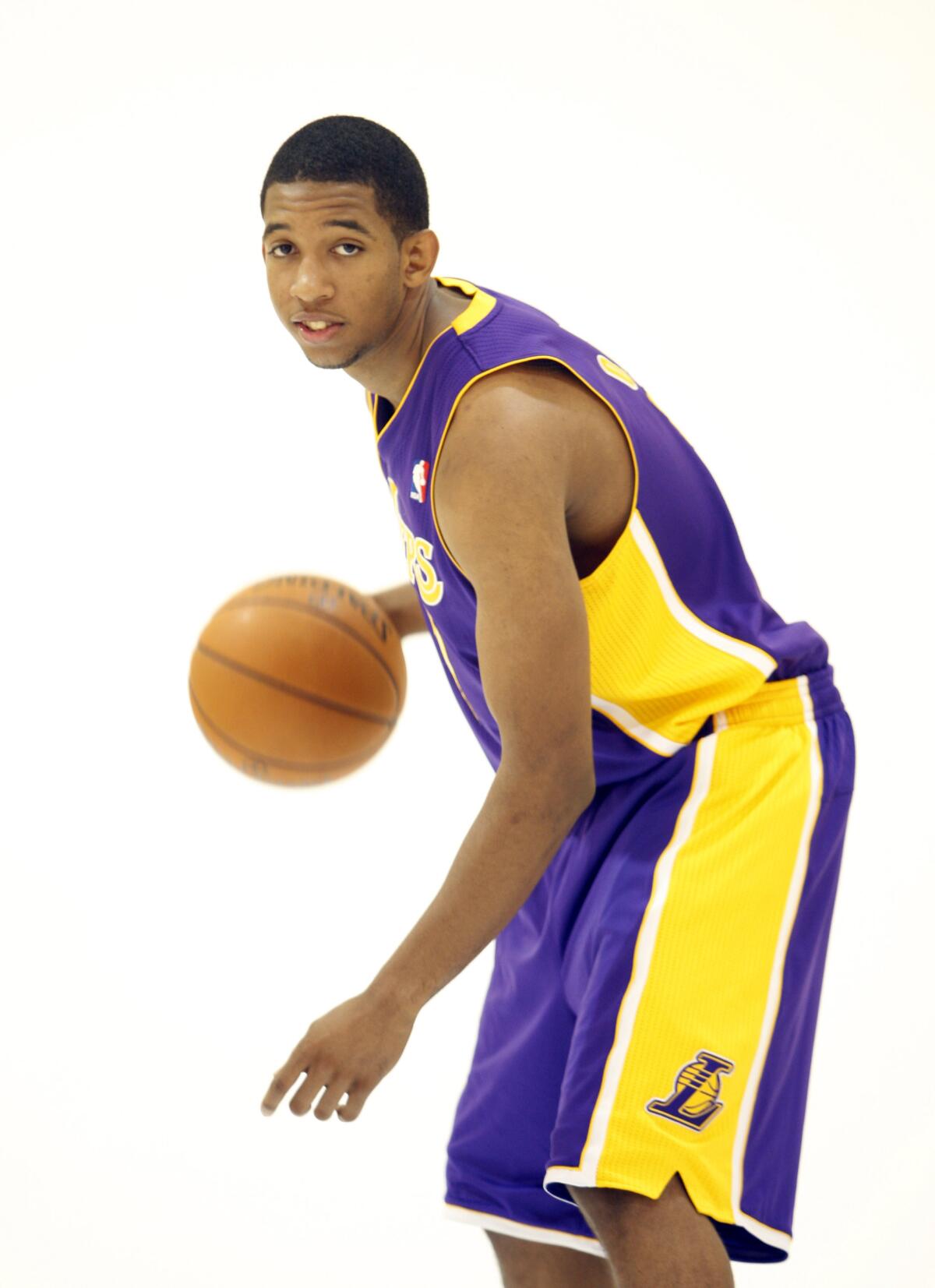 Darius Morris is holding the basketball while in his Lakers uniform
