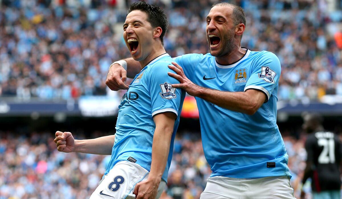 Manchester City's Samir Nasri (8) celebrates with teammat Pablo Zabaleta after scoring the team's first goal in a 2-0 victory over West Ham on Sunday.