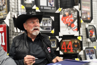 Eddie Shack signs autographs.