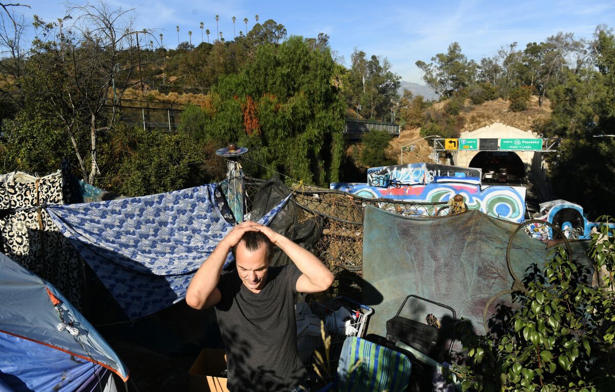 Billy Nelson comes out of his tent above the 110 Freeway in Elysian Park in Los Angeles.